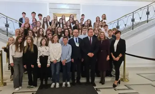 Grupa uczniów i opekunów na schodach w gmachu Sejmu RP.